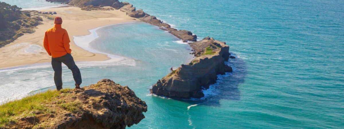 persona durante un'escursione che ammira il panorama sul mare da un fiordo
