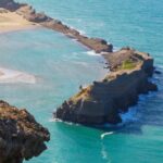 persona durante un'escursione che ammira il panorama sul mare da un fiordo